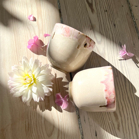 Nina kruset ligger blødt i hånden. Det er beige med en skøn topkant i røde, lyserøde, og brune nuancer.